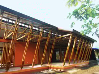 Das große Dach und die verschattete Veranda nehmen Bezug auf die ortstypische Bebauung