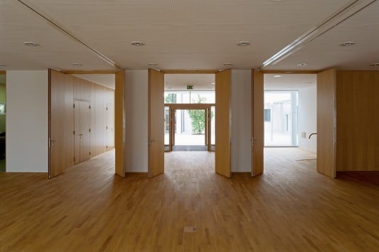 Der Pfarrsaal kann durch flexible Trennwände in drei unabhängige Räume verschiedener Größe unterteilt werden