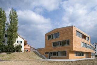 Der Neubau ist am Hang gelegen und bildet den Abschluss für den Hof des benachbarten Landwirtschaftsbetriebes