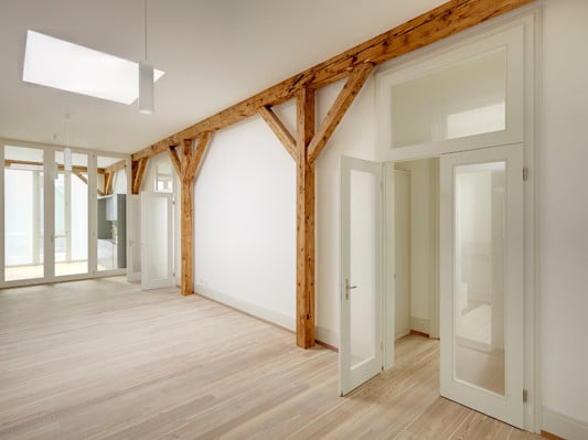 In den großen Wohnungen für Wohngemeinschaften ist das alte Holztragwerk der Lagerhalle erhalten 