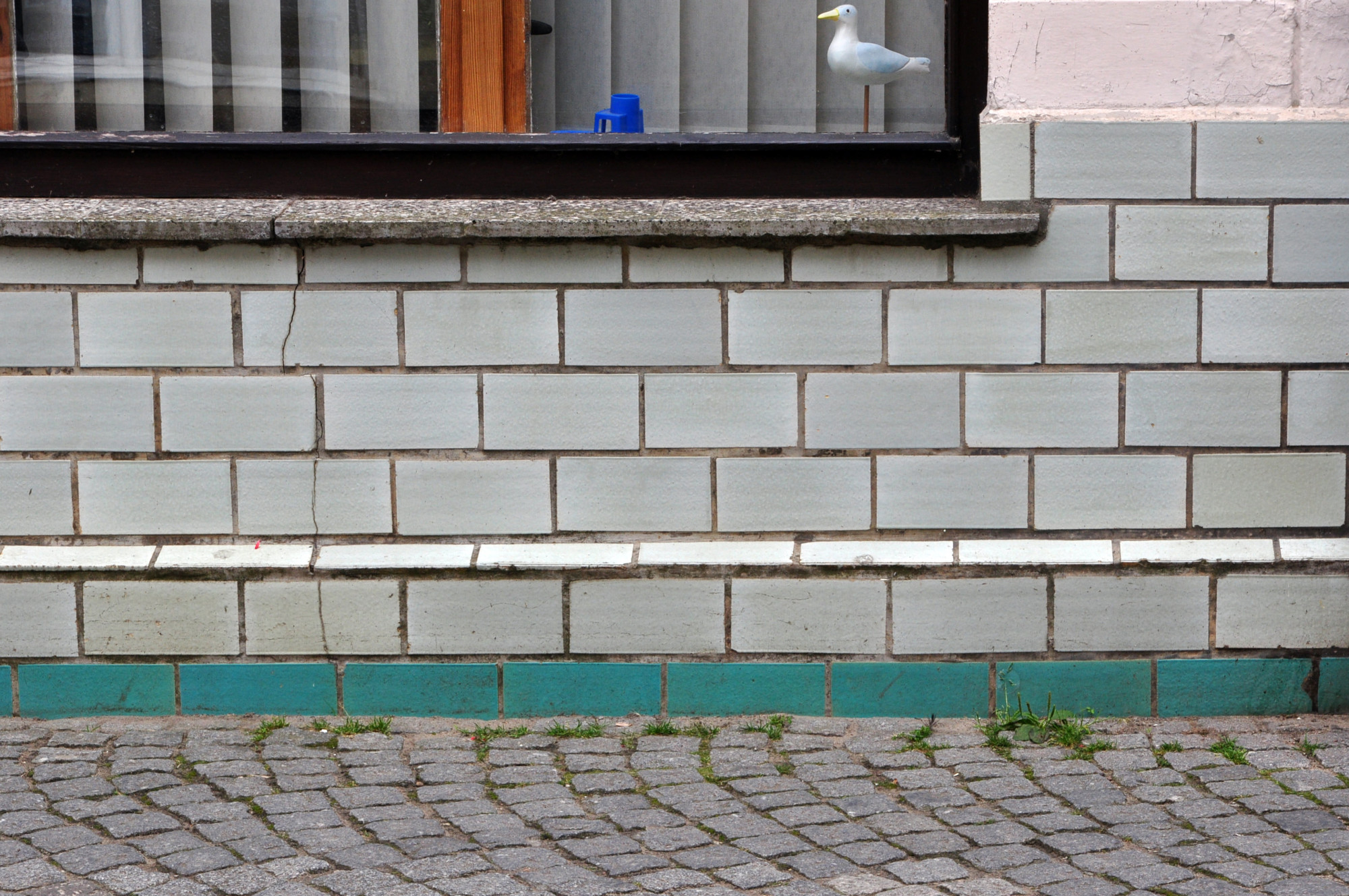 Bruchschäden an glasierten Fassadenfliesen durch Setzungsrisse