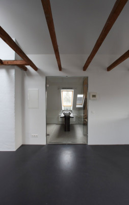 Dunkle Dachbalken, weiße Wände und grauer Linoleumboden (Produkt: DLW Linoleum Uni Walton)