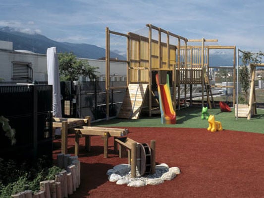 Unterschiedlich farbliche Gummigranulat-Flächen gliedern die Außenfläche des Kindergartens Sillpark in Innsbruck/A von ATP Architekten und Ingenieure, Innsbruck/A