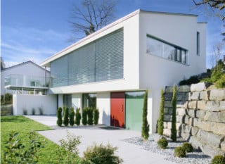 Ansicht von Süd-Ost mit geschlossenen Sonnenschutzlamellen vorm Wohnbereich im Obergeschoss