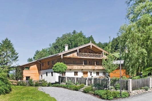 Zur Straßenseite zeigt sich das ehemalige Bauernhaus traditionell mit einem großen Balkon auf der Giebelseite