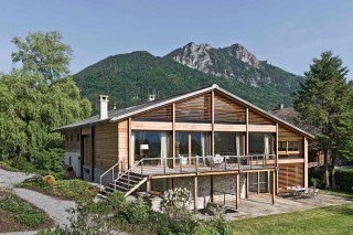 Ansicht des restaurierten Bauernhauses mit teilweise geöffneten Fensterfeldern