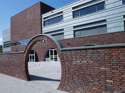 Mauern, Bögen und Tore prägen den Schulbau