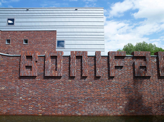 Name der Schule als Schriftzug aus Backstein