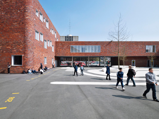 Der zentrale Schulhof ist gefasst von unterschiedlich hohen Gebäudeteilen