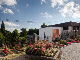 Das schlichte, weiße Gebäude bestimmt den Eingang des Friedhofes