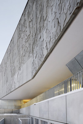 Betonfassade aus Baumrinden, am auf das EG gesetzten Veranstaltungssaal