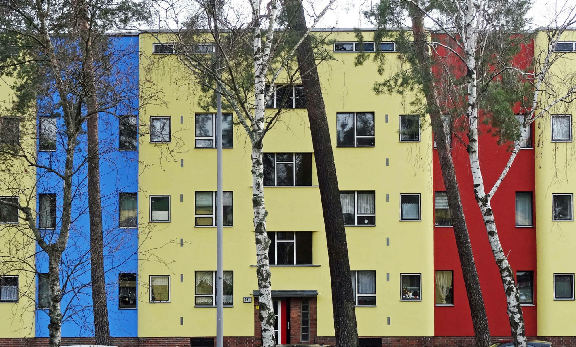 Die Farbgebung verlieh der zwischen 1926 und 1931 erbaunten Waldsiedlung Onkel Toms Hütte in Berlin-Zehlendorf den Namen Papageiensiedlung, Architekten: nach Plänen der Architekten Bruno Taut, Hugo Häring und Otto Rudolf Salvisberg.