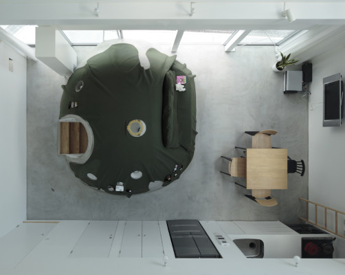 Das Badezimmer befindet sich in einem igluartigen Bau aus Beton, der zentral im Wohnraum angeordnet ist