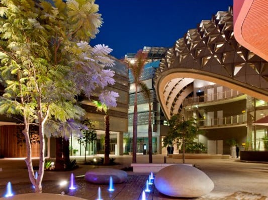 Masdar Institute bei Nacht, im Vordergrund die Bibliothek mit schattenspendendem muschelförmigen Dach