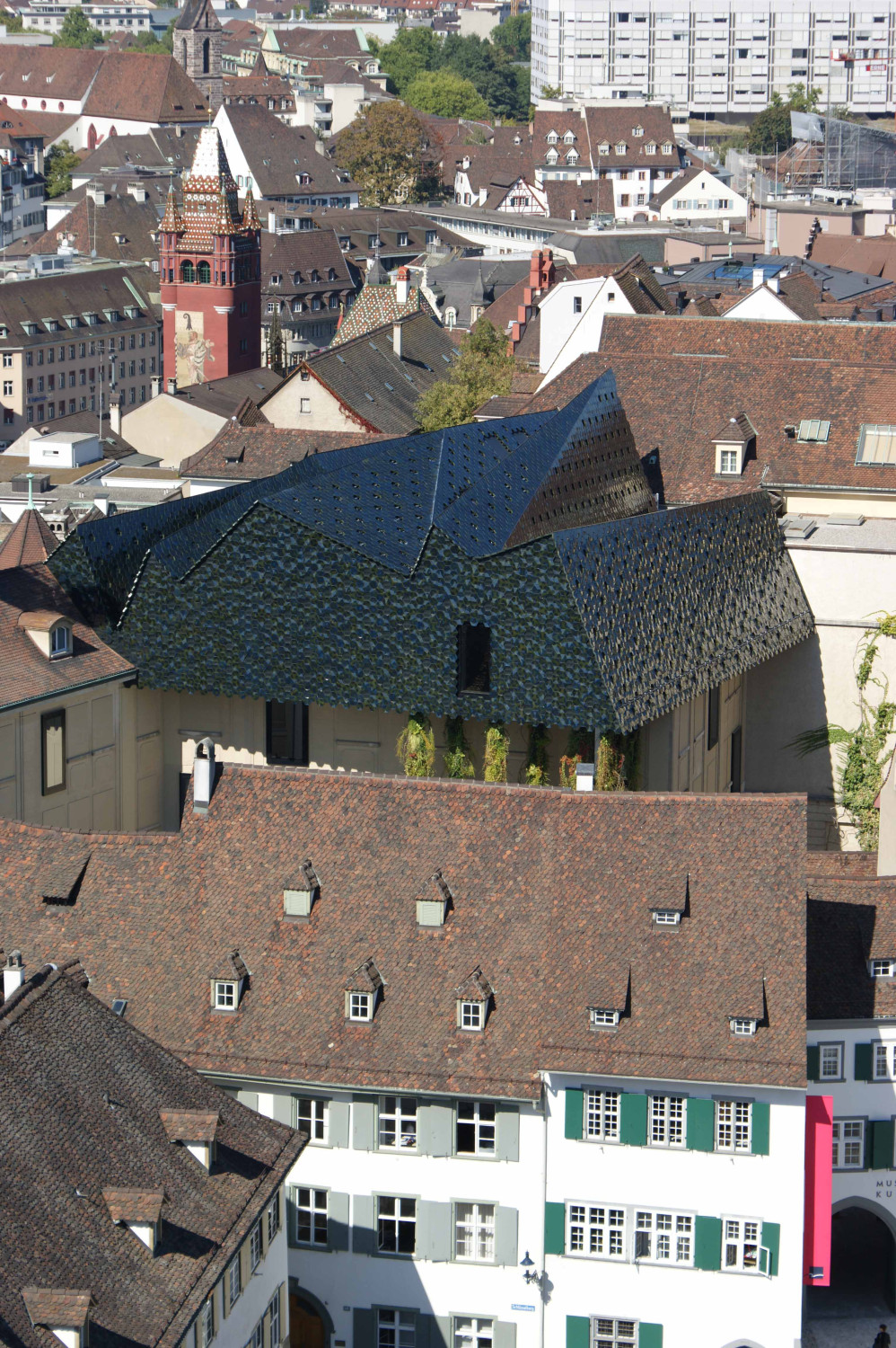 Blick vom Münsterhügel auf die gebirgsartig gefaltete und mit Keramikfliesen bedeckte Dachlandschaft