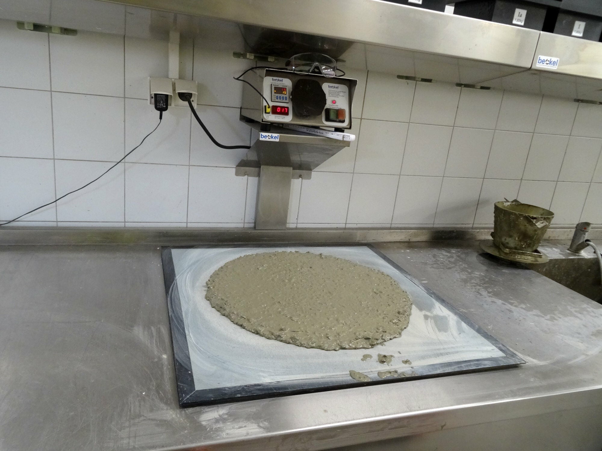 Ausbreitversuch auf dem Rütteltisch: Der Durchmesser des Frischbetons gibt Aufschluss über die Konsistenz und damit indirekt über den w/z-Wert.