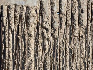 Freiliegende Bewehrung infolge abgeplatzter Betondeckung mindert Schutzwirkung und Dauerhaftigkeit des Bauteils.