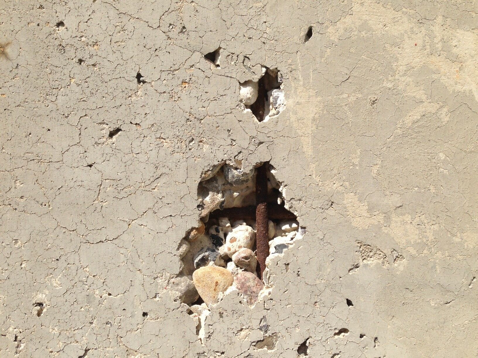 Freiliegende und korrodierte Bewehrung nach dem Abplatzen der schützenden Betondeckung.