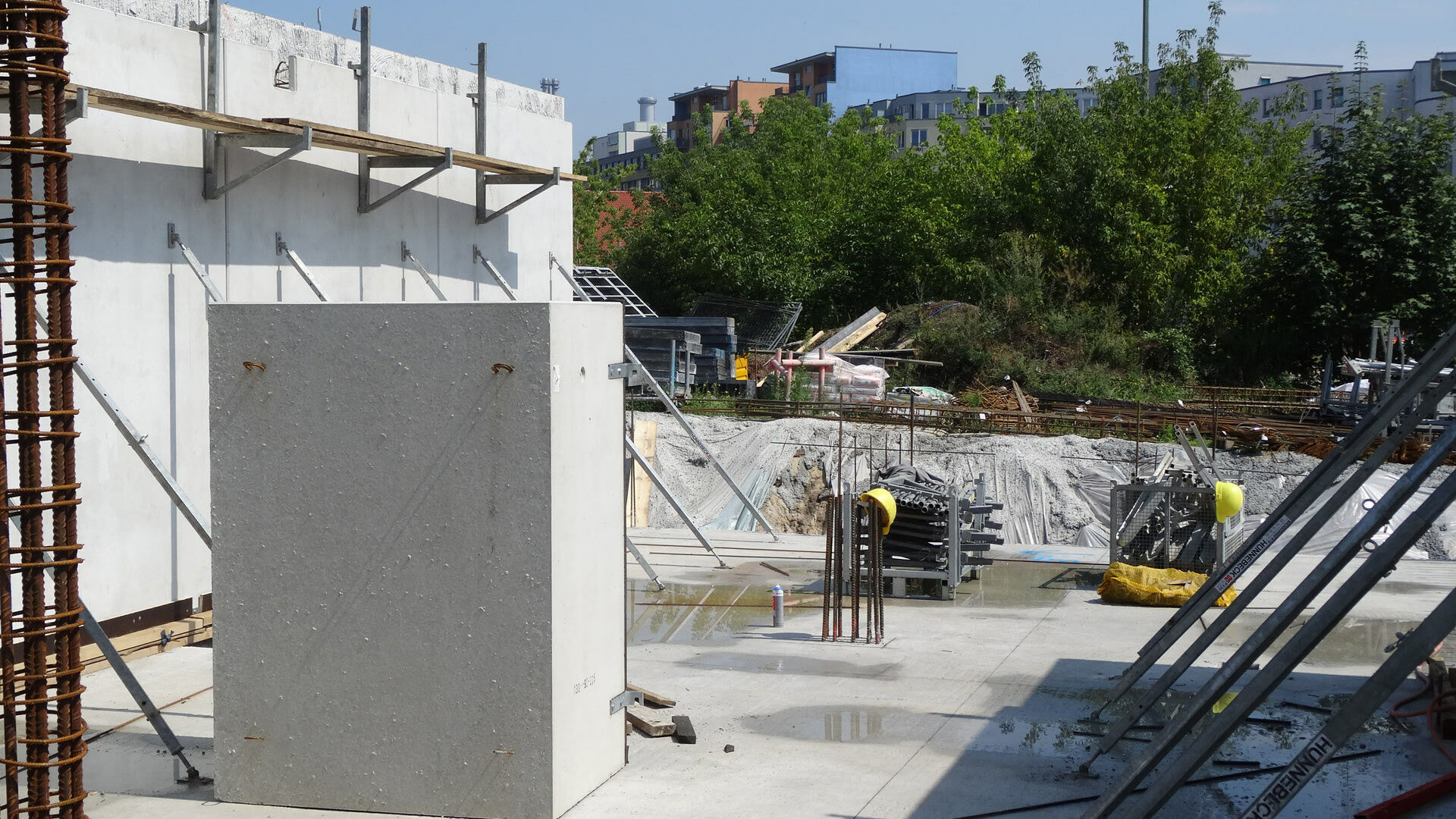 Montage im Bereich massiver Stahlbetonfundamente mit ausgerichteten Bauteilen, Schrägstützen und angrenzenden Rohbauzonen