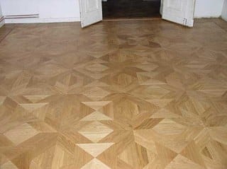 Tafelparkett besteht aus verschieden großen Holzelementen, die zu die zu geometrischen Mustern zusammengefügt werden