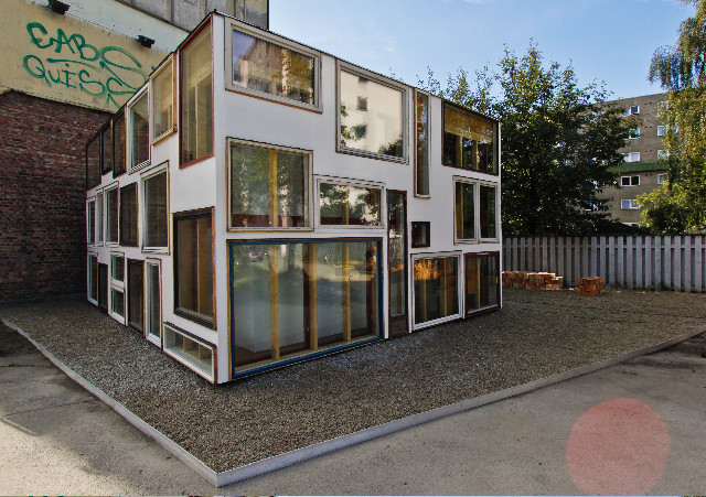 Die Fassade ist von unterschiedlich großen Fenstern bedeckt
