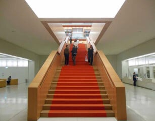 Zentrale Holztreppe mit rotem Teppichläufer in der Staatsbibliothek Unter den Linden in Berlin.