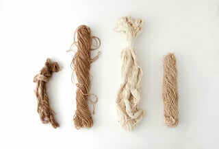 Garne aus Nesseln, Jute, Seide und Wolle (von links nach rechts)