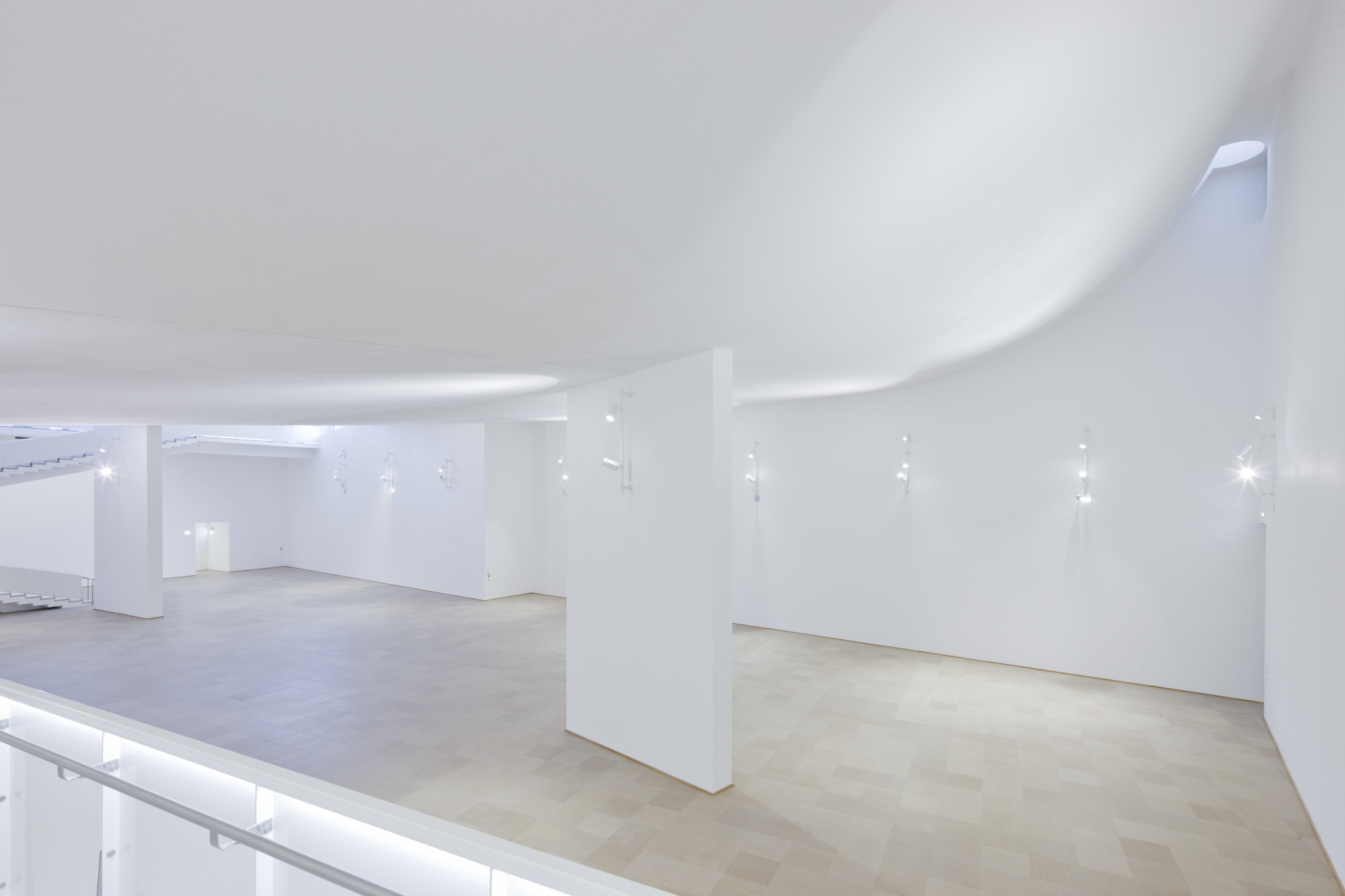 Die konvex geformte Betondecke prägt den Charakter der Ausstellungs­räume im Untergeschoss