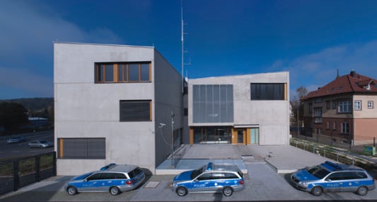 Auf der Gebäuderückseite umfassen die Baukörper den erhöhten Innenhof