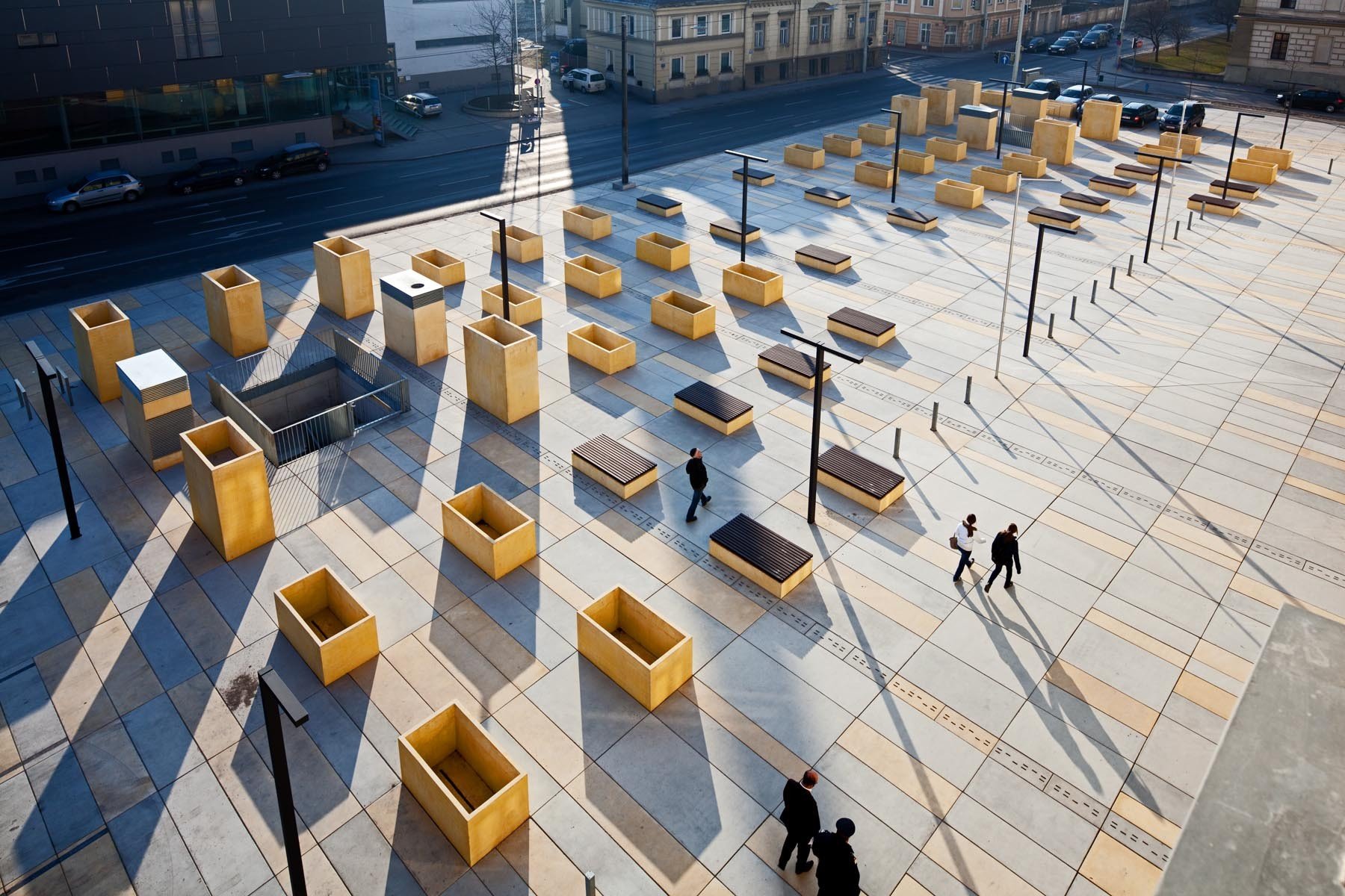 Platz mit unterschiedlich hohen Sitzgelegenheiten, Hochbeeten und Pflanztrögen vor dem alten Gerichtsgebäude