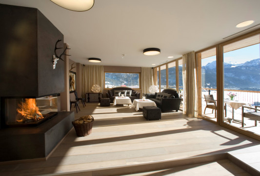 Kaminzimmer mit vorgelagerter Terrasse und Aussicht auf die Berge