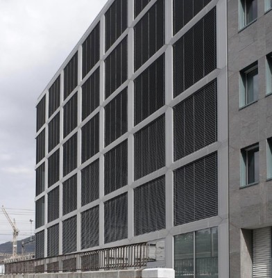 Das strenge Fassadenraster mit geschlossenen Jalousien aus Aluminium 