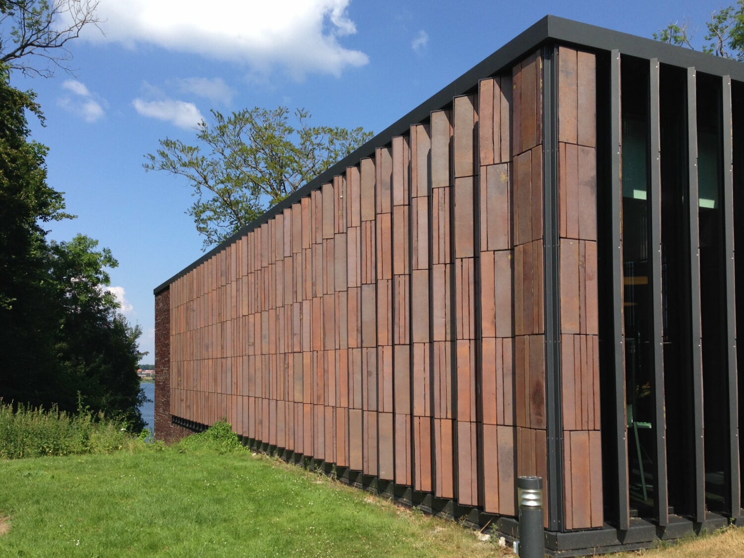 Feststehende, mit Keramik bestückte Vertikallamellen am Clay-Museum in Middlefart; Architektur: Kjaer & Richter, Aarhus