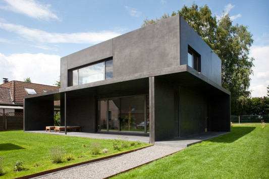 Fassade aus großformatigen, anthrazitfarbenen Sichtbeton-Platten (Süd-Ost-Ansicht)