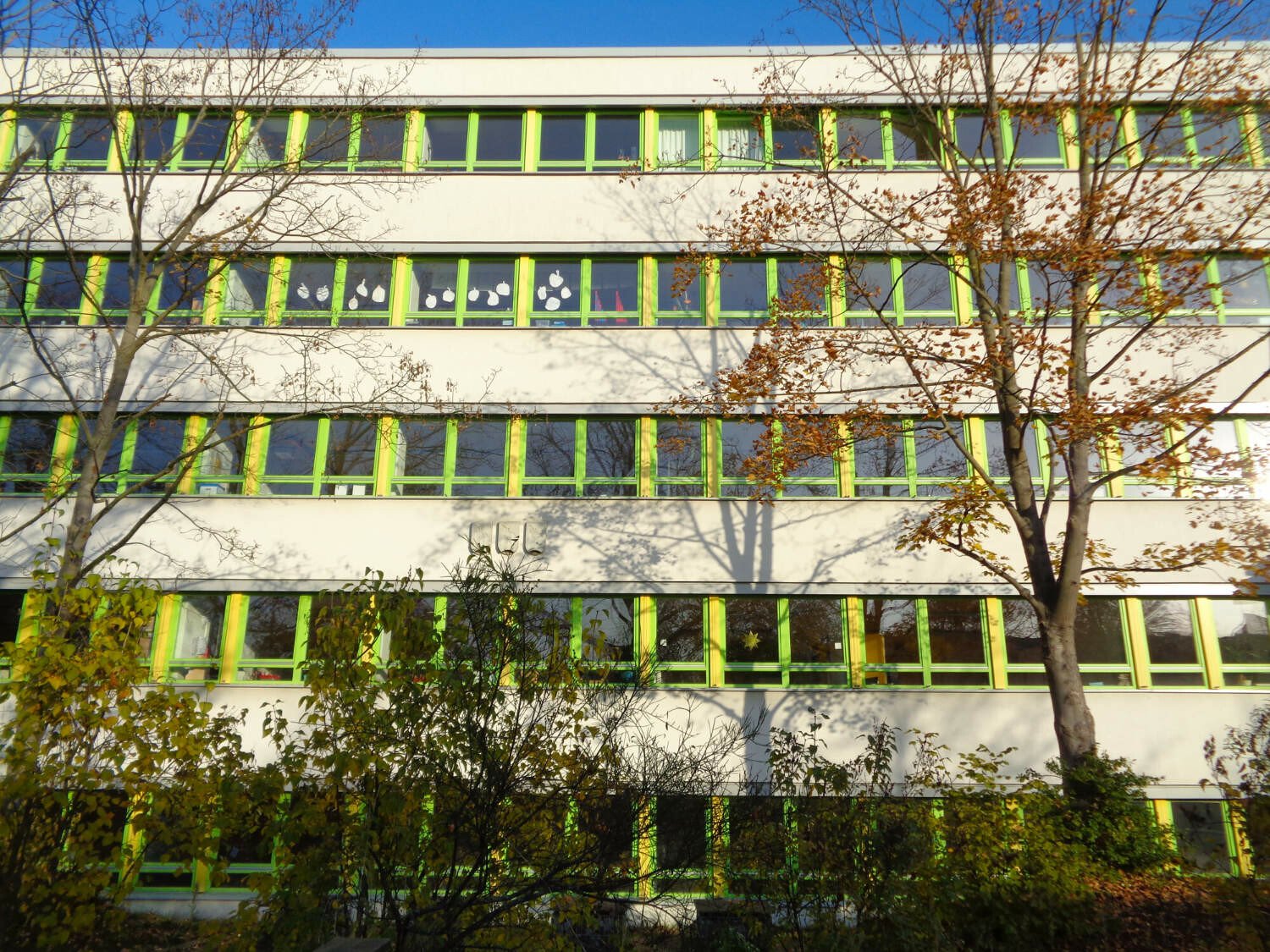 Fensterbänder erlauben eine innere anpassungsfähige Raumaufteilung und belichten die Innenäume gleichmäßig (im Bild: farbig akzentuierte Fensterbänder bei einem Typenschulbau).