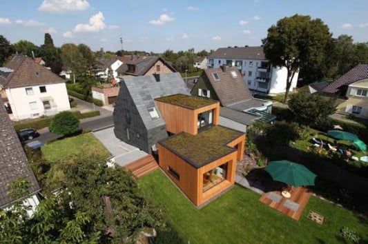 im Hintergrund der Altbau, zum Garten hin die neuen Anbauten aus Lärchenholz