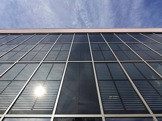 Die Ostfassade mit integrierten Dünnschicht-Modulen einer Industriehalle in Bönen