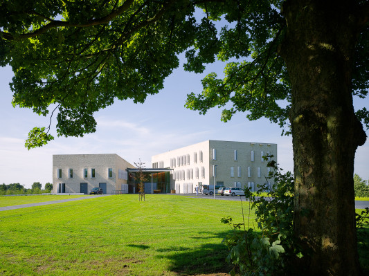 Südwestansicht: Die Erschließung erfolgt über die zentrale, zweigeschossige Halle zwischen den beiden Gebäuderiegeln