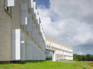 Nordostansicht: Fassade aus hellen Wasserstrichziegeln; die Fensterläden sind mit ländlichen Motiven bedruckt