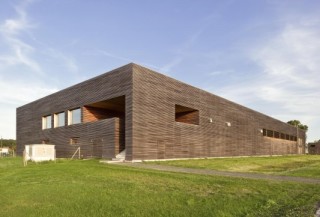 In einem L-förmigen Einschnitt auf der Nordseite sind eine Außentreppe mit Loggia sowie mehrere Fensterelemente untergebracht