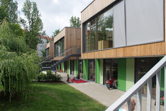 Gartenseite mit holzverkleideten, großflächig verglasten Boxen
