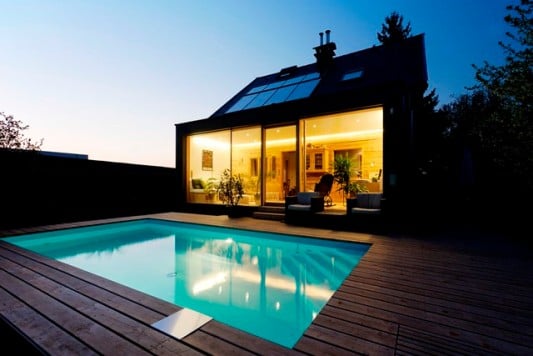 Vor dem großflächig verglasten Anbau befindet sich ein Pool