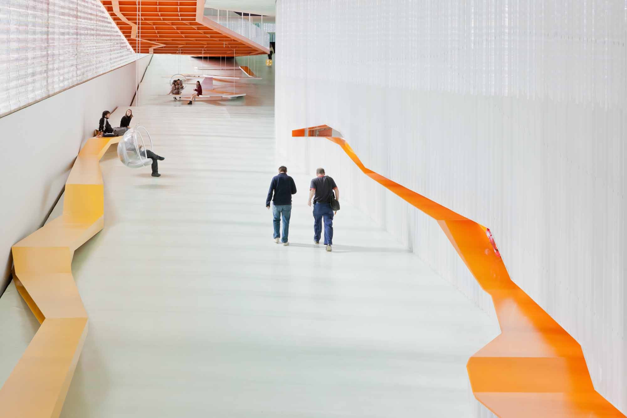 Vom Auditorium führt das als Rampe ausgebildete Foyer zurück zum Eingangsbereich. Eine weitere Rampe verbindet diese Ebene mit den oberen Rängen des Auditoriums
