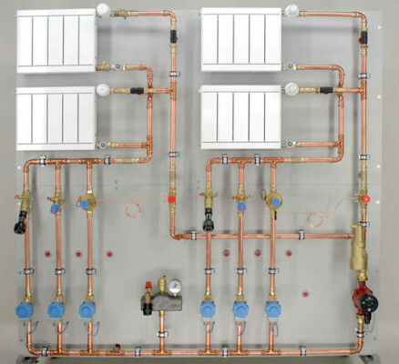 Schulungsstand einer Pumpenwarmwasserheizung mit unterer Vorlaufverteilung und vertikalen Steigsträngen
