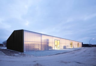 Die Werkhalle richtet sich mit einer durchgehend transluzenten Fassade aus Polycarbonat nach Norden