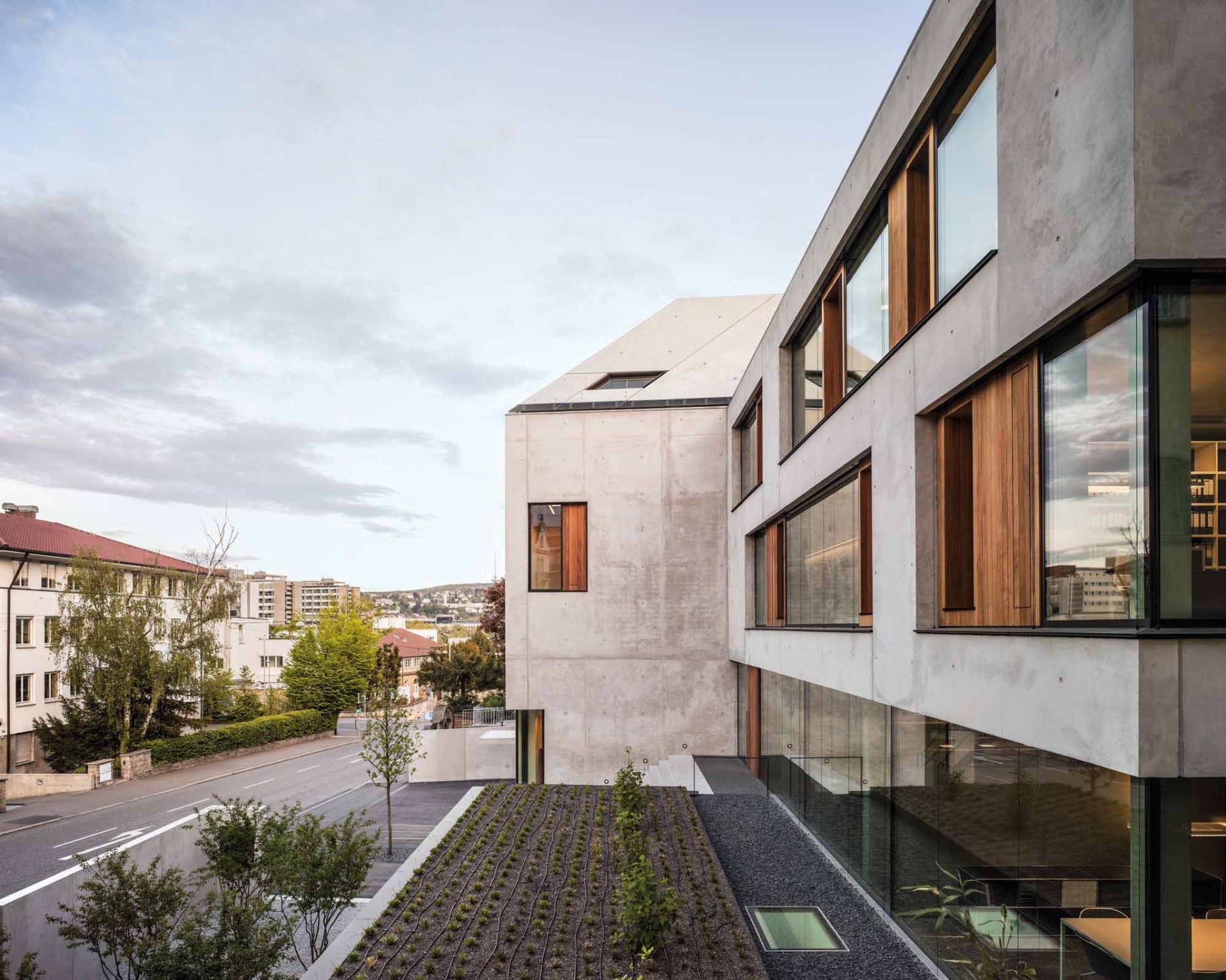 Klare Linien, viel Sichtbeton und großzügige Fensterbänder prägen den Baukörper von außen