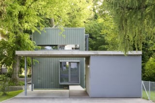 Die Erschließung erfolgt über einen langen Steg vom offenen Carport zum gerahmten Eingang