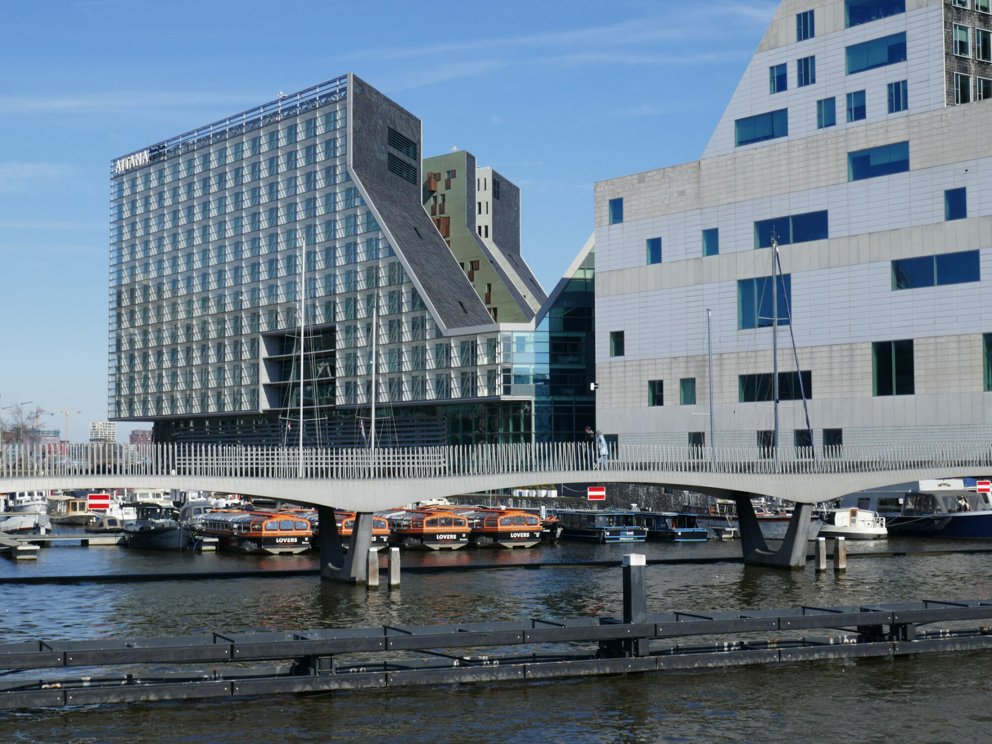 Das Ijdock in Amsterdam ist eine künstliche Halbinsel, basierend auf einem städtebaulichen Masterplan von 1997: Dick van Gameren und Bjarne Mastenbroek entwickelten die Bebauung, indem sie großräumig verschiedene Achsen in einen quaderförmigen Block schnitten. Die Dachflächen in den Schneisen sind überwiegend mit Schiefer gedeckt.
