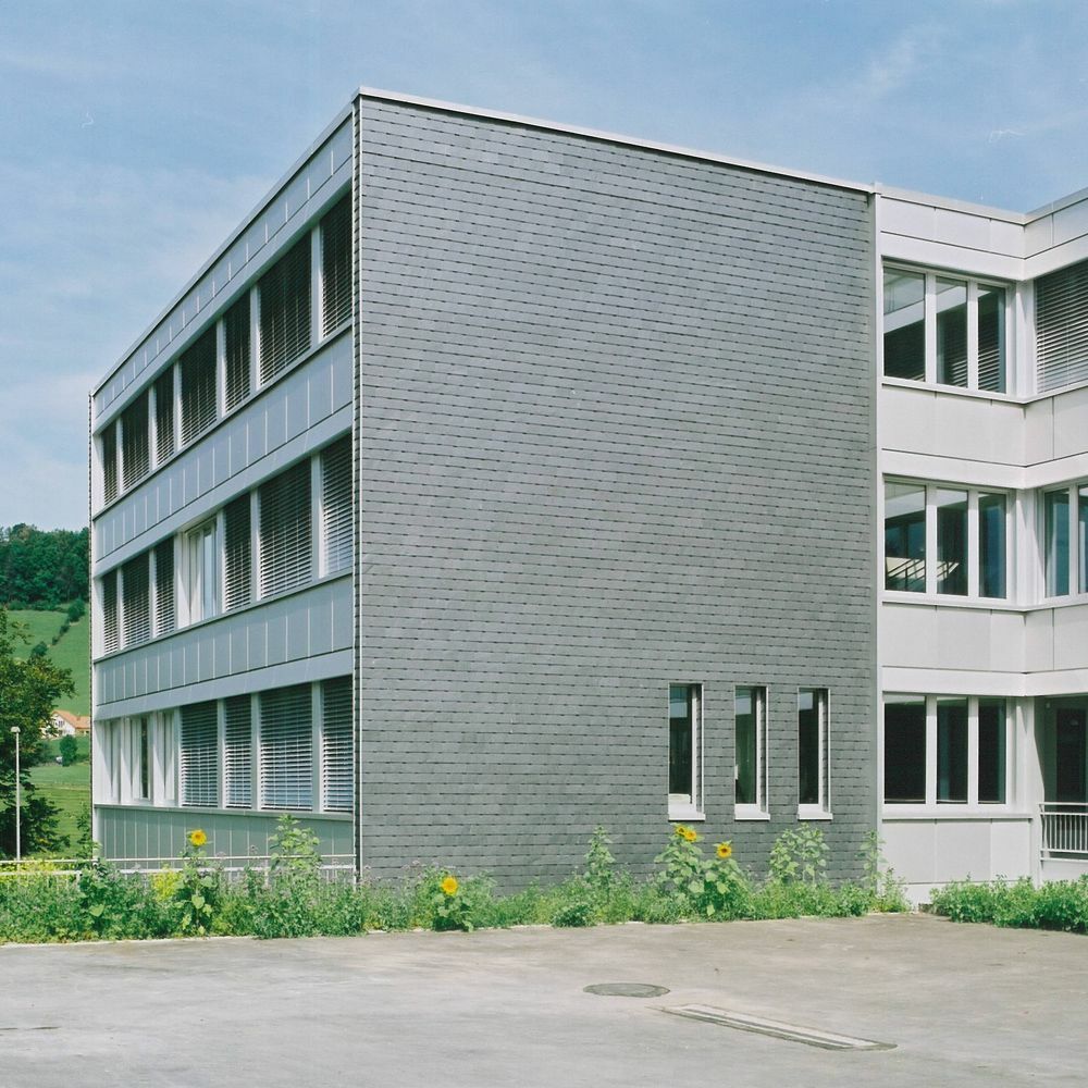 Schiefer, Glas und Aluminium prägen das Gebäude nach der Sanierung.