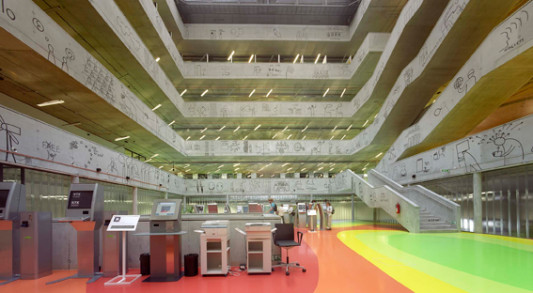 Ein rechteckiges Atrium gliedert das weitläufige Gebäude und führt viel Tageslicht bis ins erste Obergeschoss